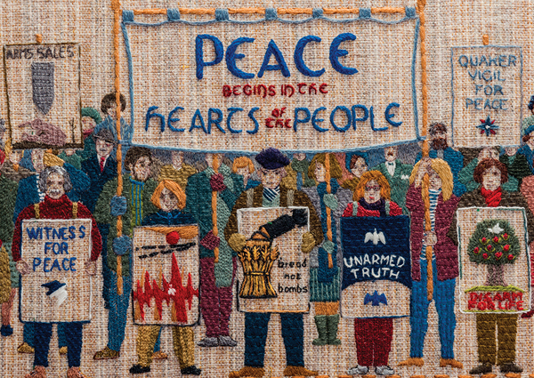 'Peace begins in the hearts of the people' section of the Quaker Tapestry with different people holding historic Quaker posters