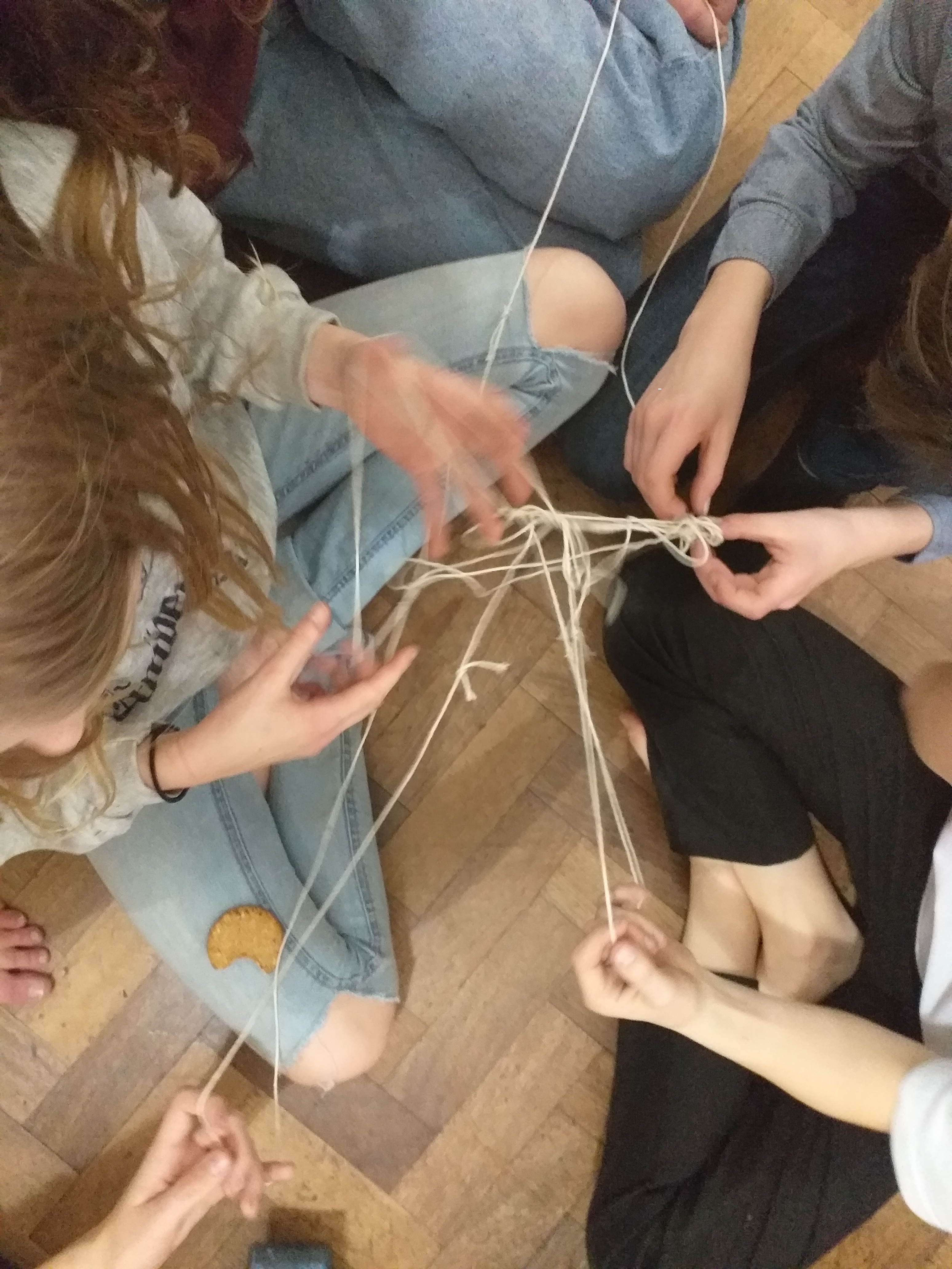 Young people doing an activity to untangle string