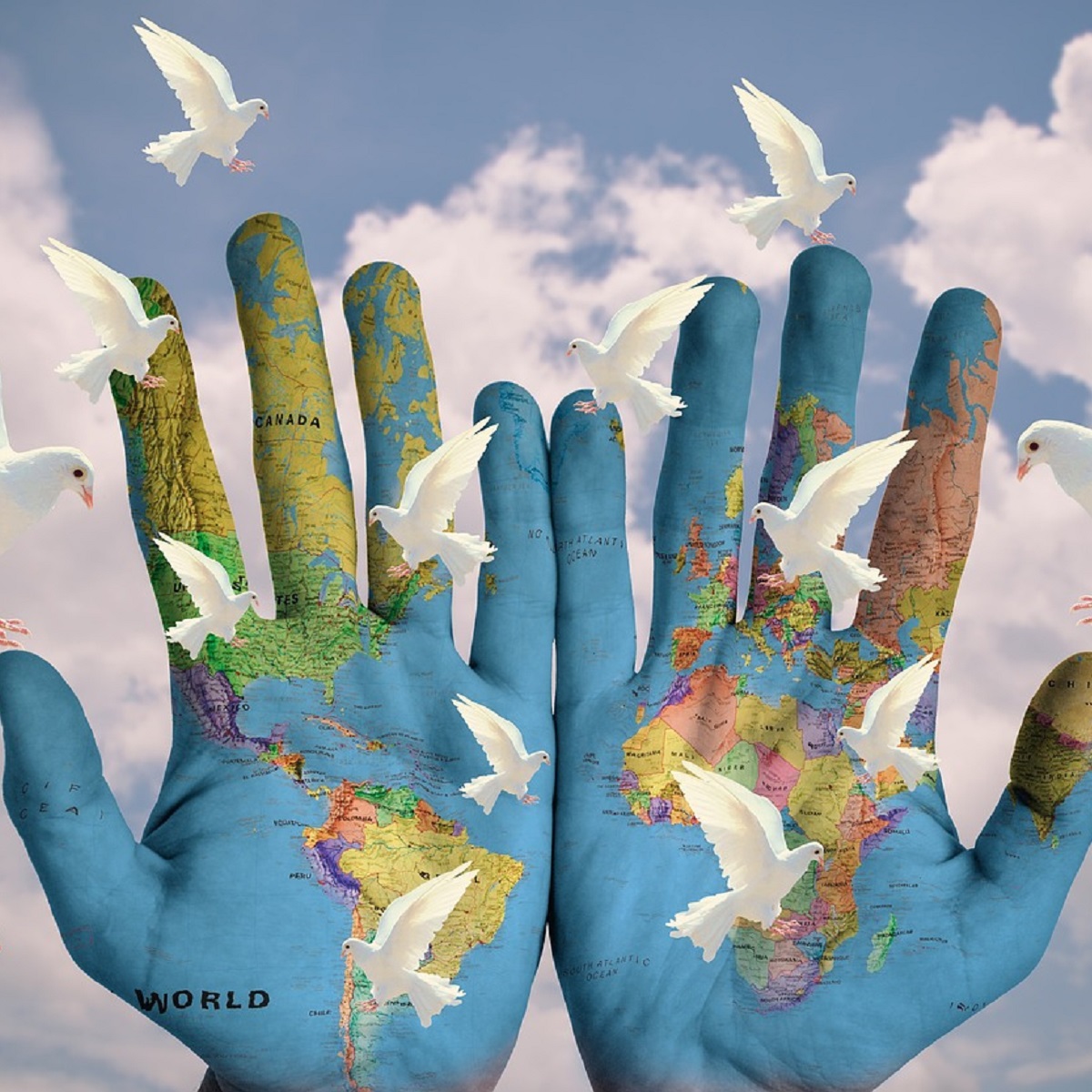 Two hands painted as a map of the world with doves flying around them