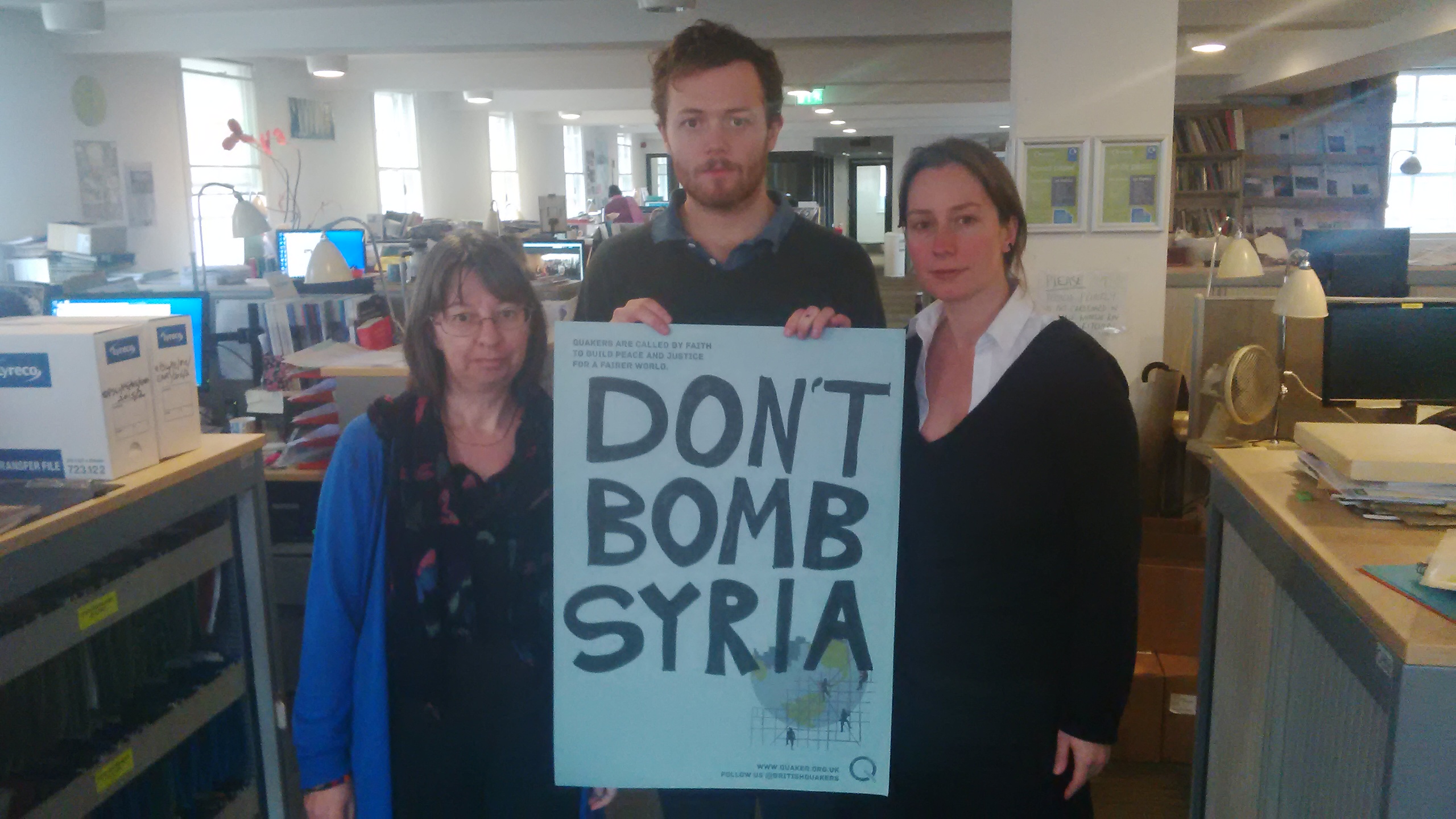 Quaker staff holding a banner with the slogan don't bomb Syria