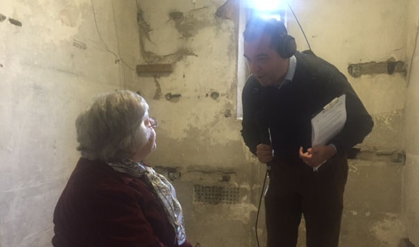 Woman being interviewed in a cell