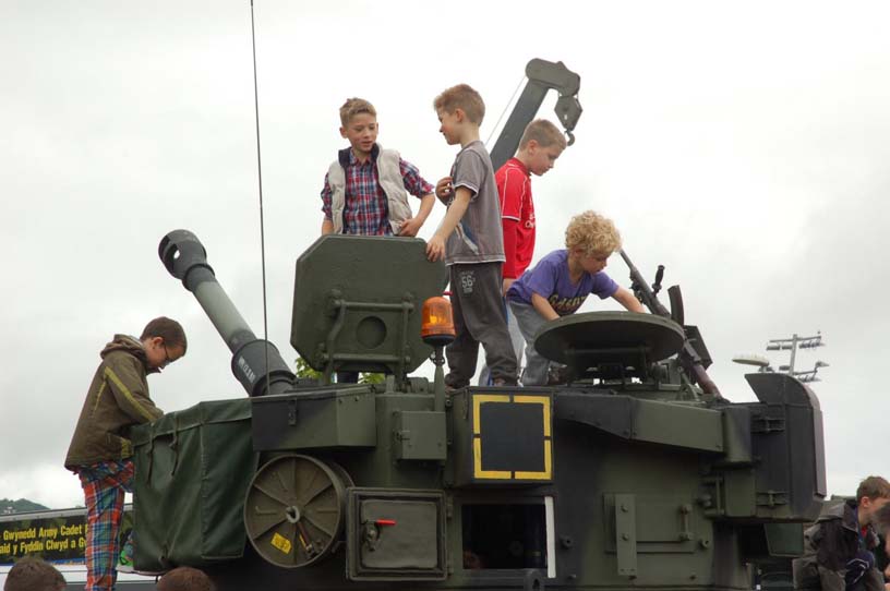 Children climbing over military tank