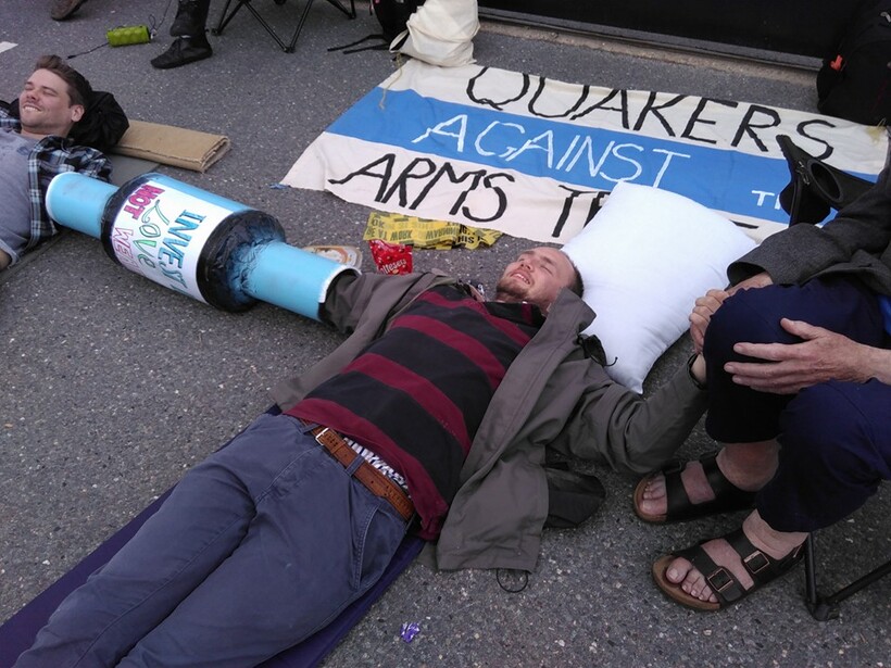 Sam Donaldson lies on the road outside Atomic Weapons Establishment, Burghfield, connected to other protesters