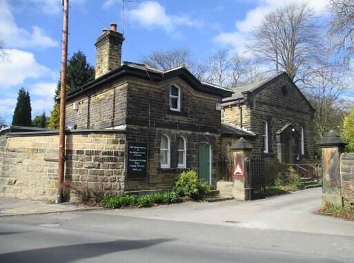 Grey stone building on a side road with Quaker Meeting House sign. 