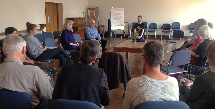 A group of Quakers sitting in a circle in a Quaker meeting room.