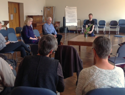 A group of Quakers sitting in a circle in a Quaker meeting room.