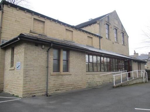 Large grey stone building with accessible slope to entrance.