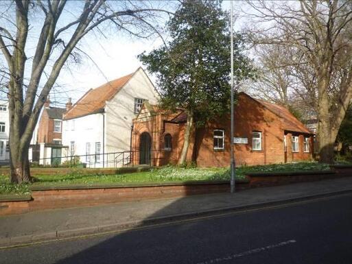 Complex of white pebble-dash and red brick buildings.