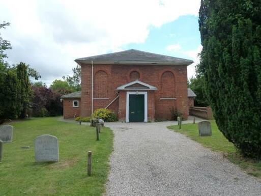 Fairly plain building with a plot and burial ground.