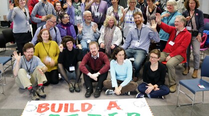 People gathered in front of a banner that reads "build a better world". 