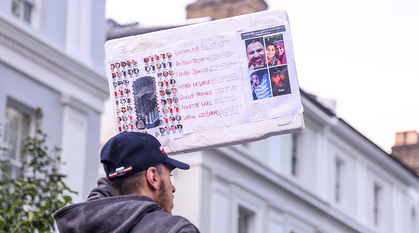 A man holds up the names of those who died in the Grenfell Tower fire.