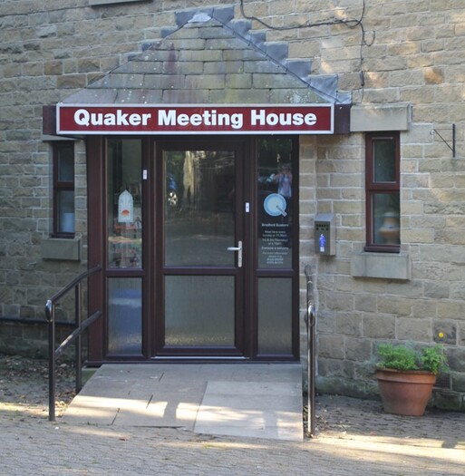 Grey stone building entrance with 'Quaker Meeting House' written above it. 