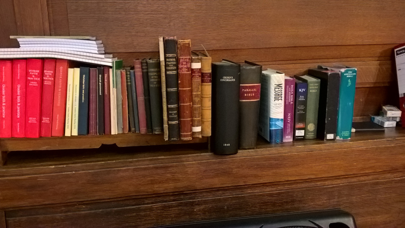 the red book alongside bibles on shelf