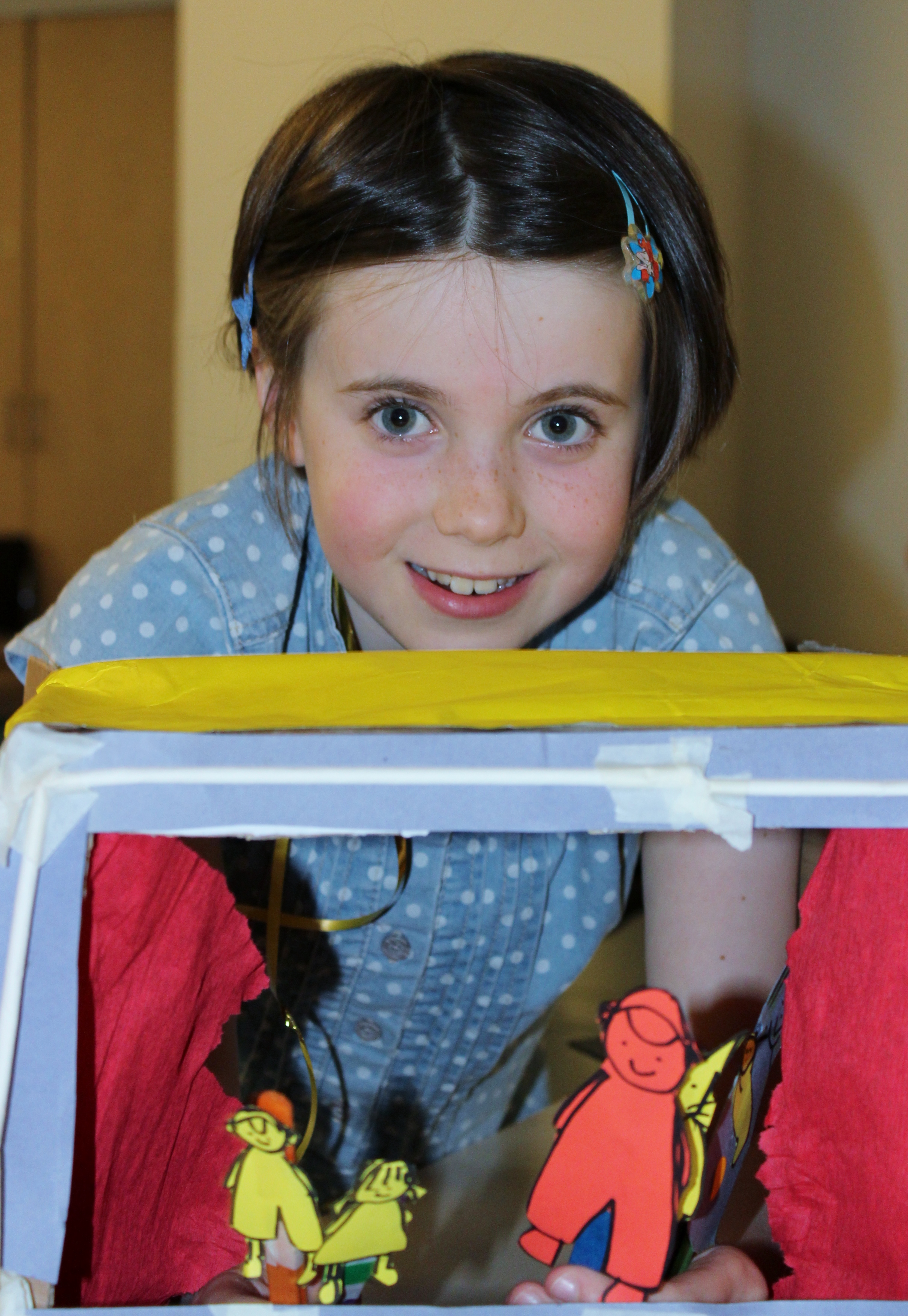 A child playing with colourful paper puppets