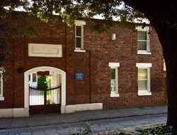 a two storey brick building with a blue sign reading Quaker meeting house