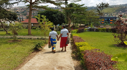Two women walking down a path holding hands