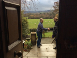 Two people shaking hands in a doorway