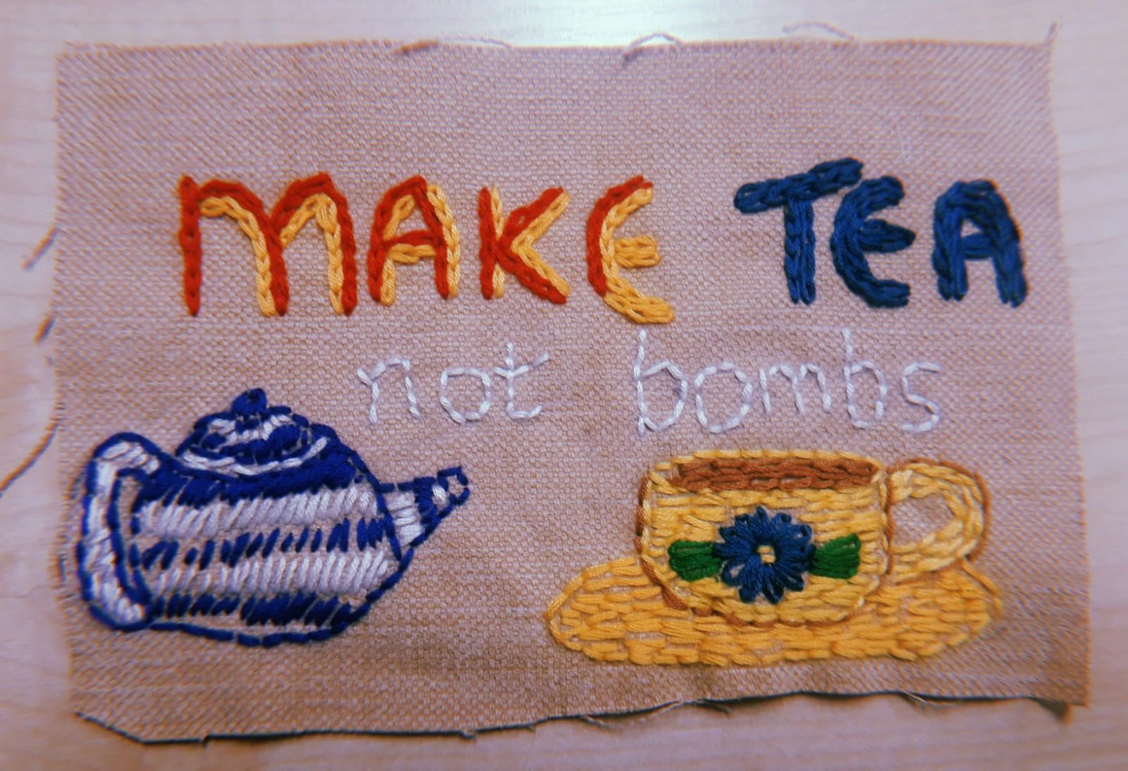 teapot stitches say make tea not bombs 