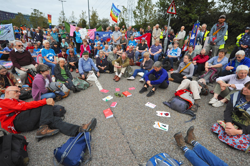 Crowd of people sitting in the road with banners