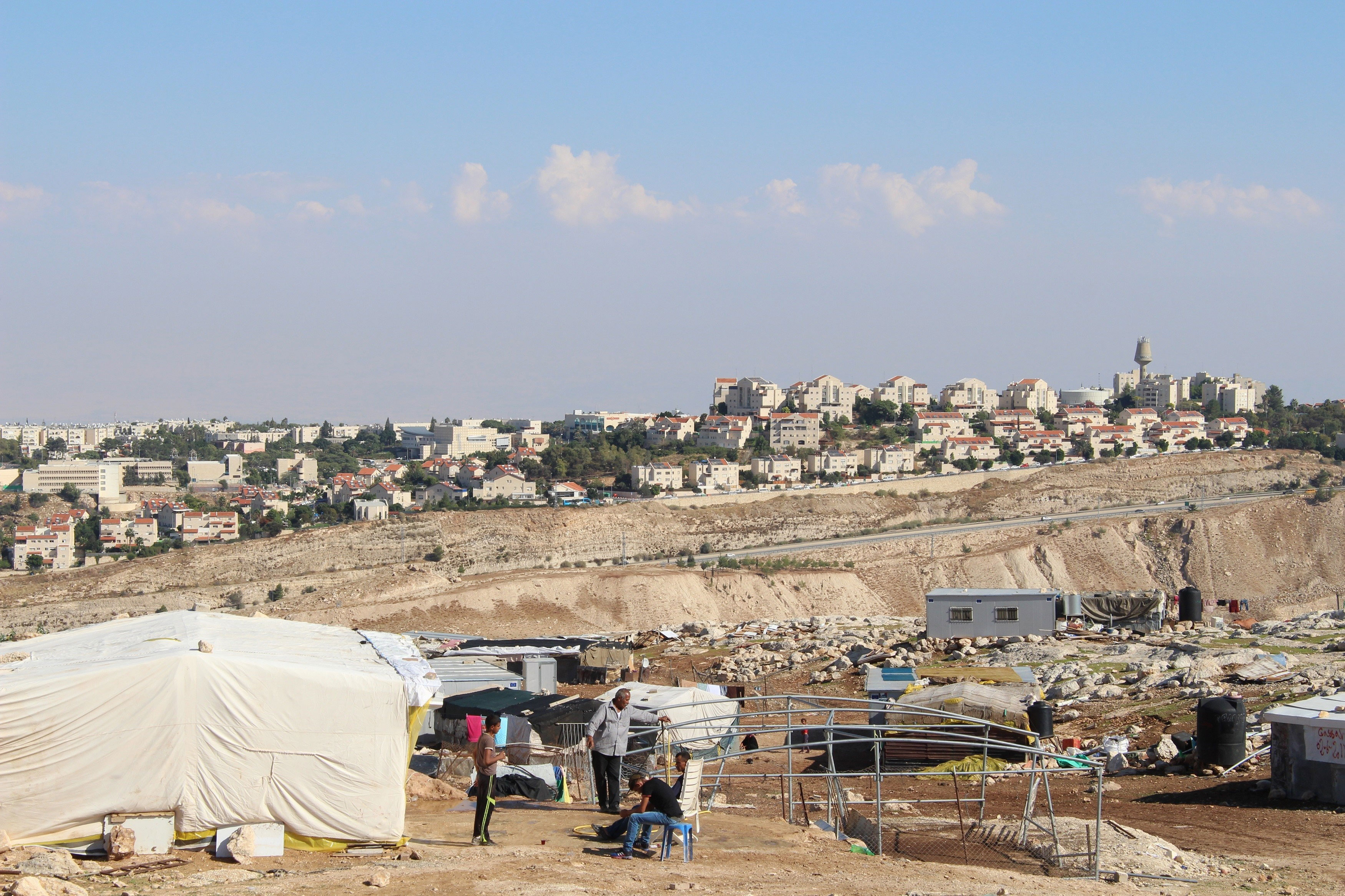 Palestinian tents with settlement behind 