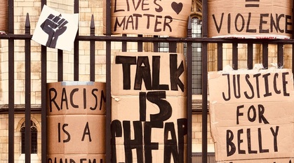 handmade black lives matter placards tucked into the railings outside westminster abbey