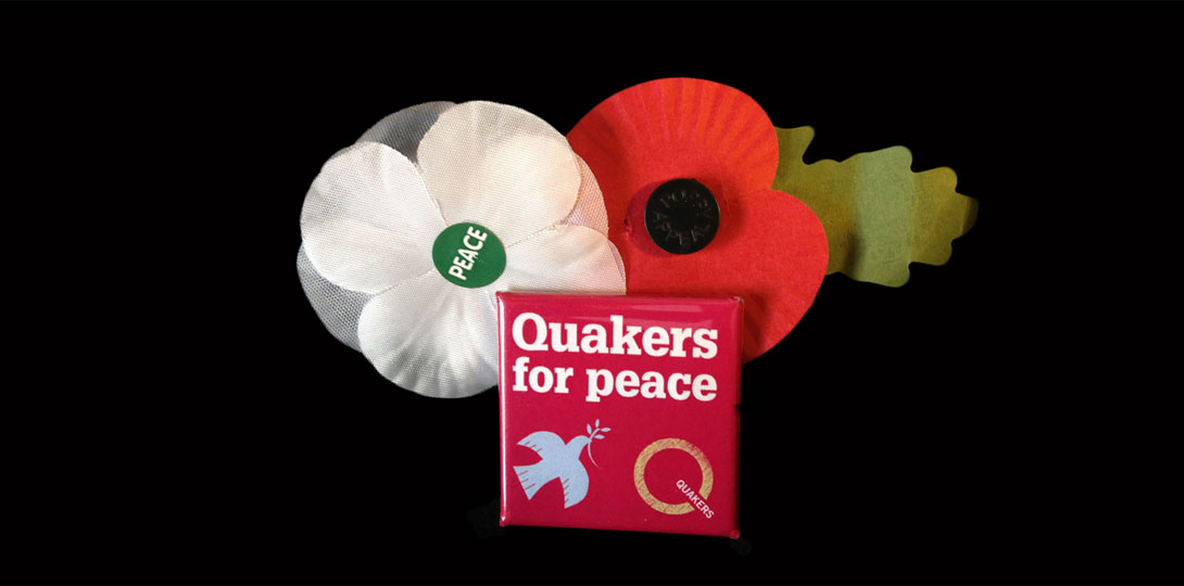 A red and a white poppy with a peace badge