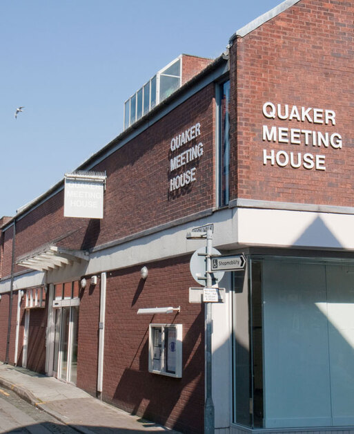 First-floor space above a shop, 'Quaker Meeting House' white lettering affixed to brickwork above the retail units. 