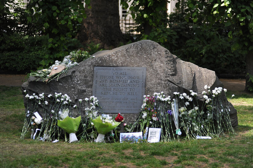 the conscientious objectors memorial with labelled white carnations laid on the stone with names of conscientious objectors on them