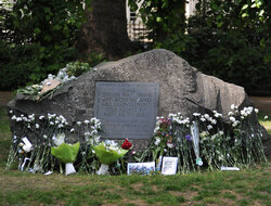 the conscientious objectors memorial with labelled white carnations laid on the stone with names of conscientious objectors on them