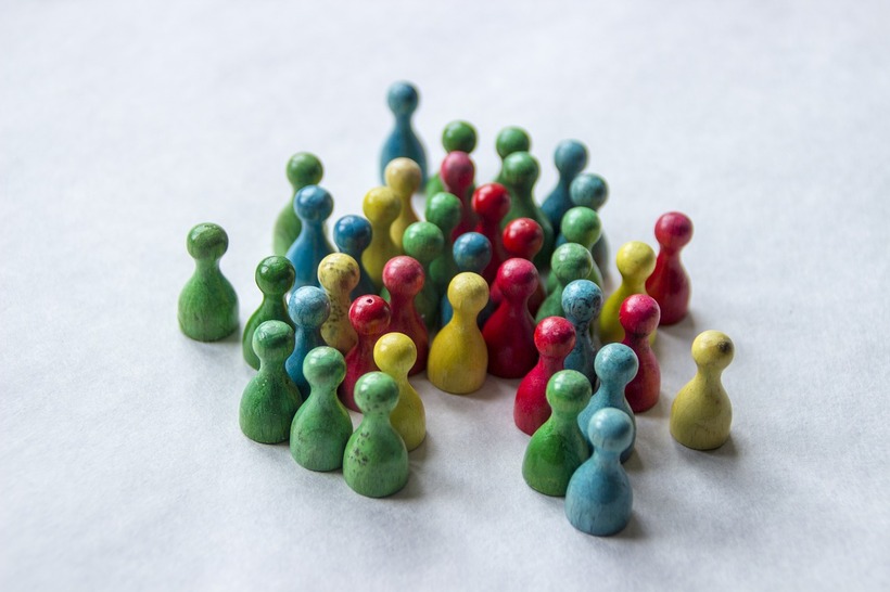 different coloured game pieces /meeples clustered together looking like they're having a conversation