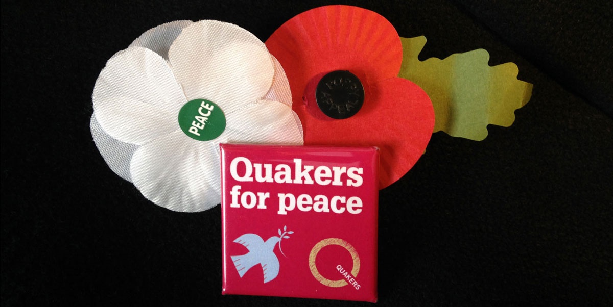 two poppies, red and white with Q peace badge
