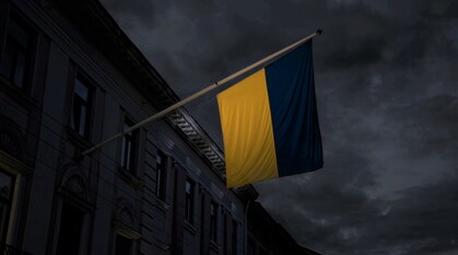 Ukraine flag hanging from a building on a dark and cloudy evening