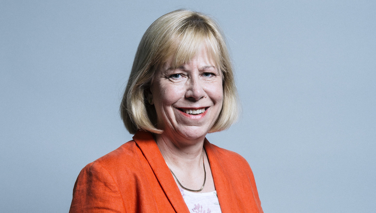 Blonde woman against blue background wearing an orange suit