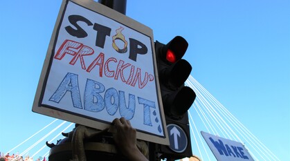 Placard on a climate march reads: stop fracking about