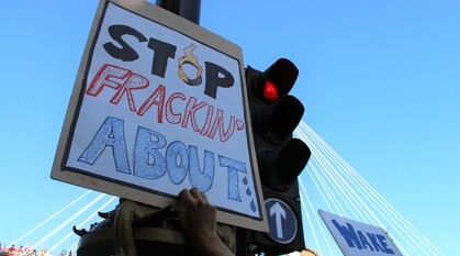 Placard on a climate march reads: stop fracking about