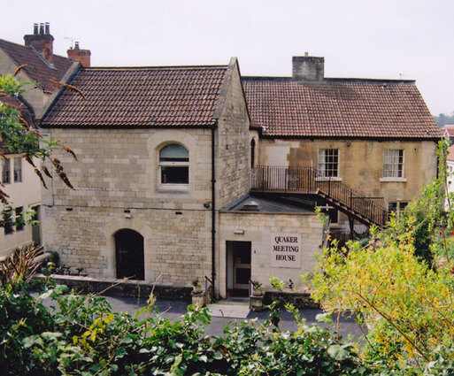 Stone townhouse with rounded windows and large 'Quaker Meeting House' sign.