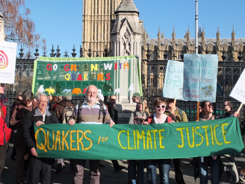 People holding banner in front of Parliament