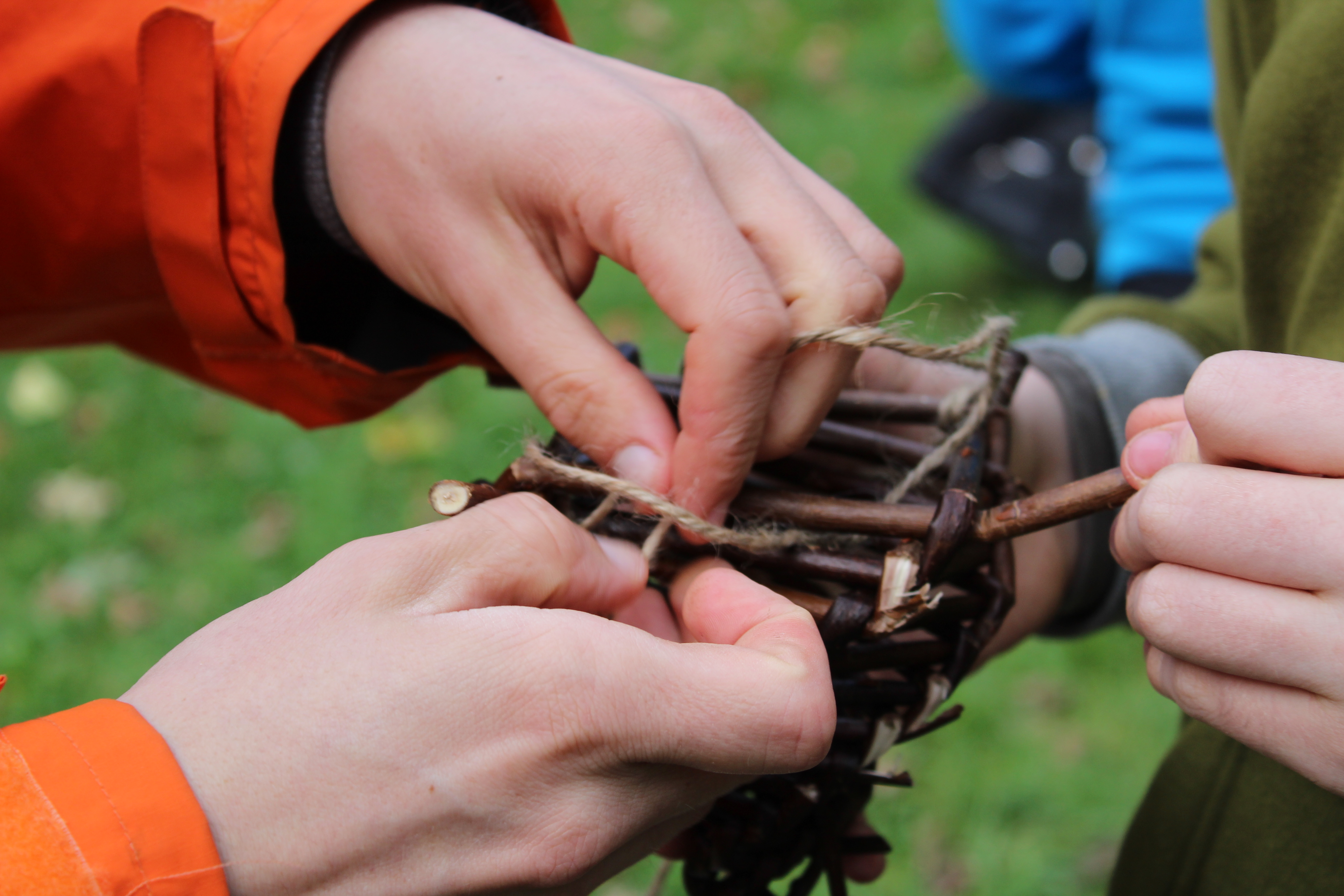 hands weaving a bamboo basket