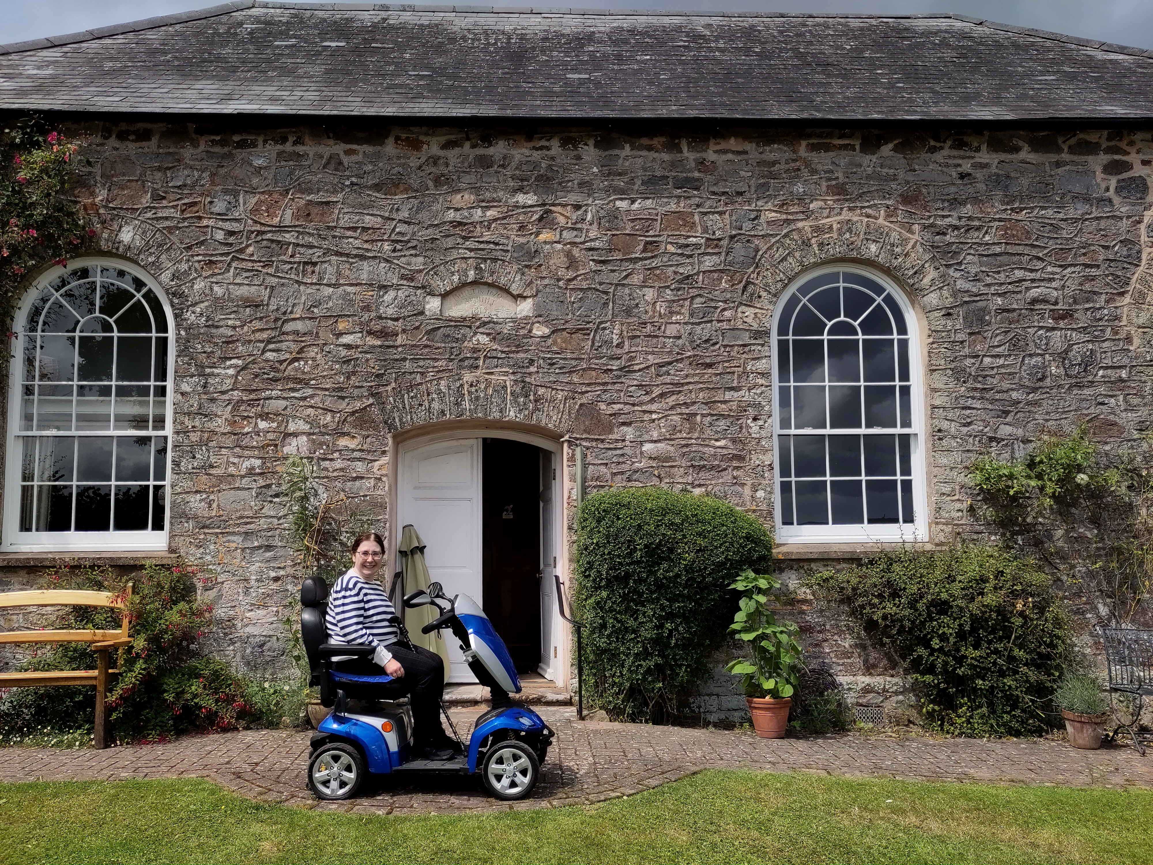 Friend on a motorscotter outside a Quaker meeting house