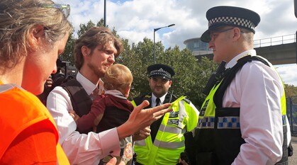 Man with a baby talking to police officers