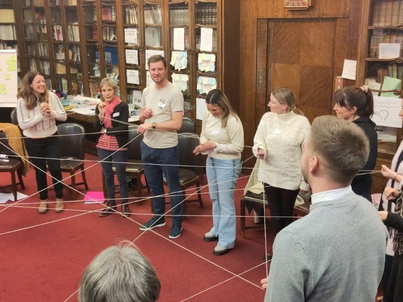 People in library holding string
