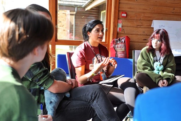 three people sat on arm chairs in discussion