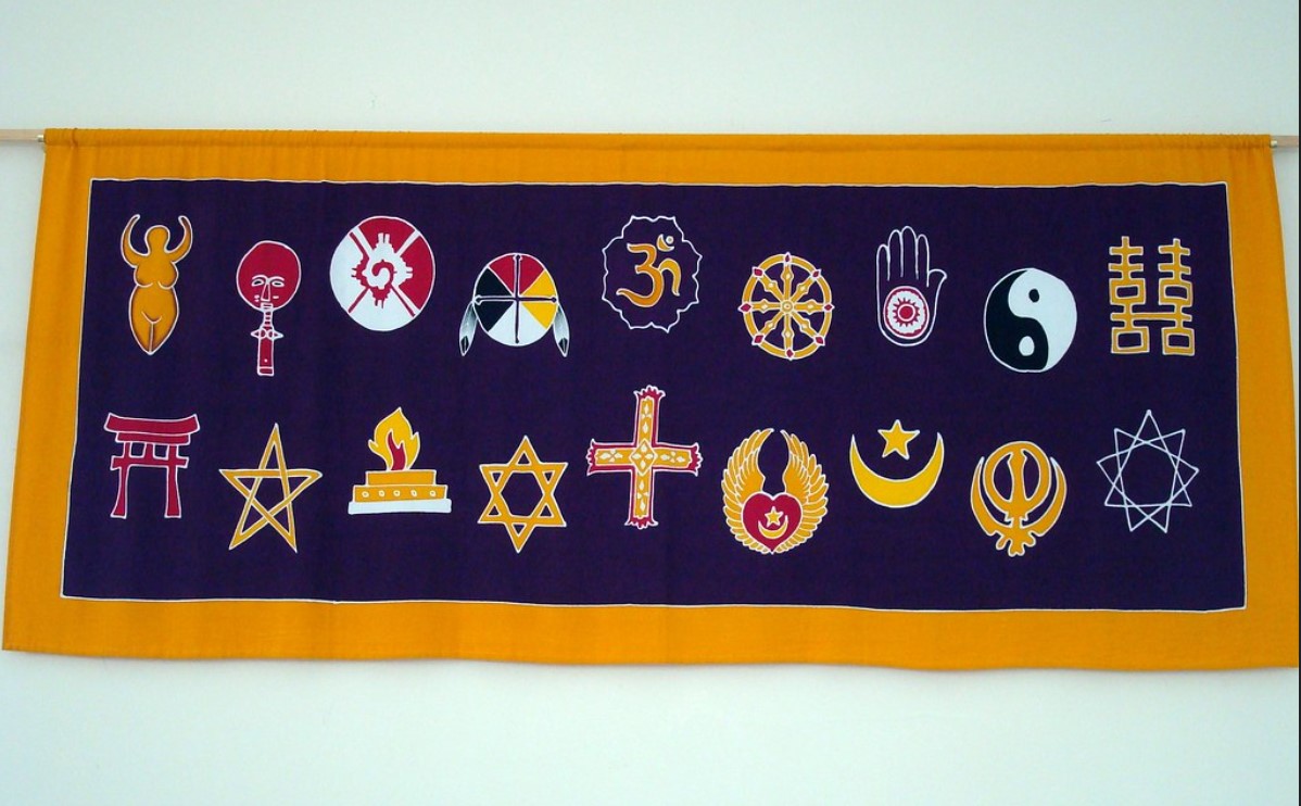 embroidered bannaer with navy background and lots of different faith symbols. 