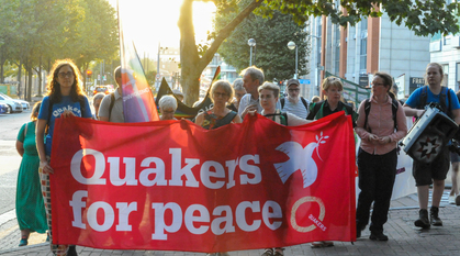 People walking forwards with Quakers for Peace banner and in blue Quakers for Peace T-shirts