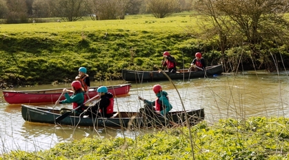 Young people learn to canoe together on a river