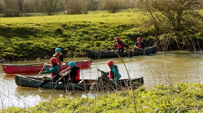 Young people learn to canoe together on a river