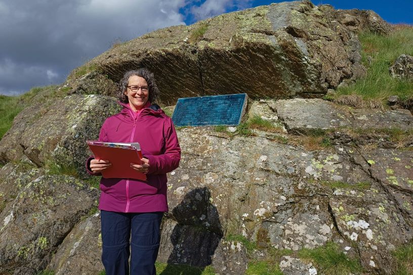 Woman standing in front of rock