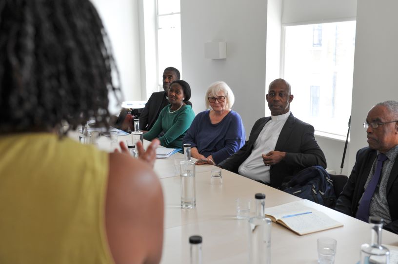 Woman talking to a table of other people