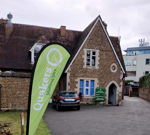 Stone building with arched doorway and green signage