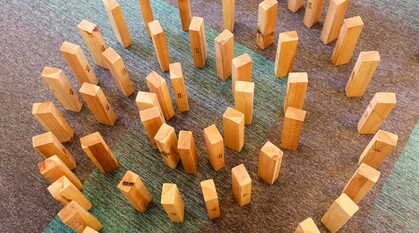 Wooden blocks arranged in a spiral pattern on the floor. The spiral draws you in to the centre